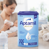 Aptamil Pronutra PRE milk powder container with a blurred background of a woman and child.