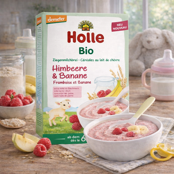 Holle organic baby food packaging with bowls of cereal and ingredients on a wooden table.