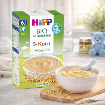 Hipp organic baby cereal packaging with a bowl of cereal on a table