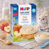 Hipp Organic Milk & Cereal package with apple illustration on a table with baby food and toys.