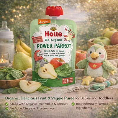 Holle organic baby food pouch with a penguin toy and fruits on a wooden table.