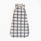Indigo Windowpane Blanket Sleeper wearable baby blanket with off-white fabric, indigo grid pattern, and sleeveless design