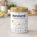 Kendamil premium toddler milk canister on a kitchen counter with bananas in the background