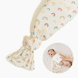 Rainbows Swaddle II swaddle blanket set with cream fabric, rainbow pattern, and matching cream snuggle band