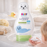 Hipp baby shampoo and shower bottle with a child holding soap bubbles in a bathtub setting.